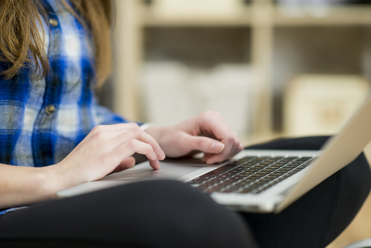 Student on laptop writing scholarship essay